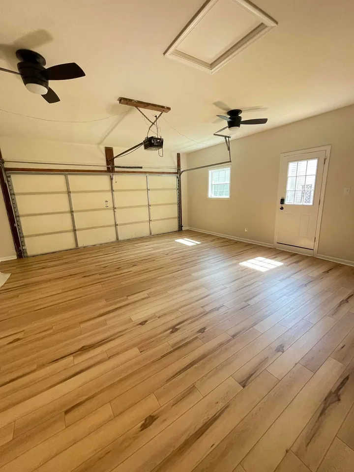 The same garage after the drywall was installed, finished, and painted, with LVP flooring laid.
